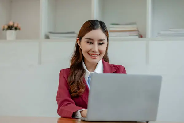 Businesswoman is sitting and working in the office, Employee is looking for information on laptop, Recording various information on paper, Employees sit and take notes in the office.