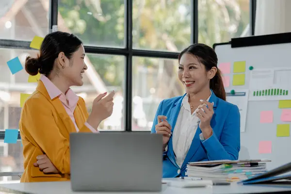 stock image Two business colleagues working together on desktop computer at office, Colleagues problem solving at computer together, cheerful business people using a laptop in an office. 