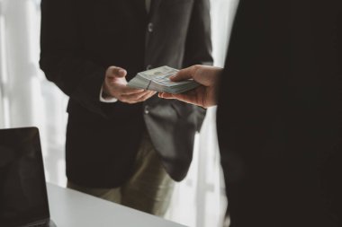 Büroda birbirine yığınla para vermek işle ilgili bir nedenden dolayı yetkililere para vermek, iş dünyasındaki yolsuzluklardan rüşvet almak..