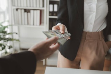 Büroda birbirine yığınla para vermek işle ilgili bir nedenden dolayı yetkililere para vermek, iş dünyasındaki yolsuzluklardan rüşvet almak..