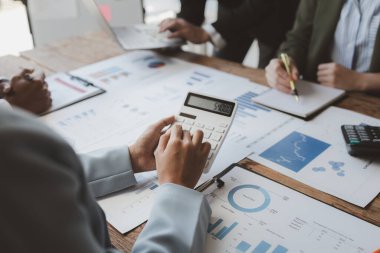 Finansal veri analizi üzerinde çalışan analist ekibi, iş stratejik planlamasının pazarlama göstergesi olarak, ödemeleri gereken vergileri hesaplıyorlar., 
