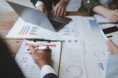 Finansal veri analizi üzerinde çalışan analist ekibi, iş stratejik planlamasının pazarlama göstergesi olarak, ödemeleri gereken vergileri hesaplıyorlar., 