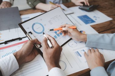 Finansal belgeleri al ve hesap makinesiyle kontrol et, şirket içindeki harcamalar için finansman planlıyorlar, toplantıya gönderilen rapora göre rakamları hesaplıyorlar., 