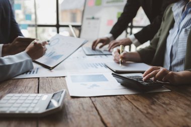Finansal veri analizi üzerinde çalışan analist ekibi, iş stratejik planlamasının pazarlama göstergesi olarak, ödemeleri gereken vergileri hesaplıyorlar., 