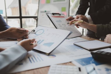 Finansal belgeleri al ve hesap makinesiyle kontrol et, şirket içindeki harcamalar için finansman planlıyorlar, toplantıya gönderilen rapora göre rakamları hesaplıyorlar., 