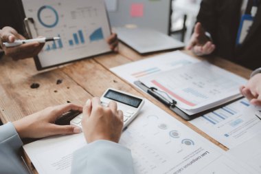 Finansal veri analizi üzerinde çalışan analist ekibi, iş stratejik planlamasının pazarlama göstergesi olarak, ödemeleri gereken vergileri hesaplıyorlar., 