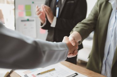 İş ortaklarıyla anlaşmalar yapmak, iş anlaşmaları imzalamak, el sıkışmak ve takım çalışması yapmak, iş adamı ve iş kadınının el sıkışırken vurulması,