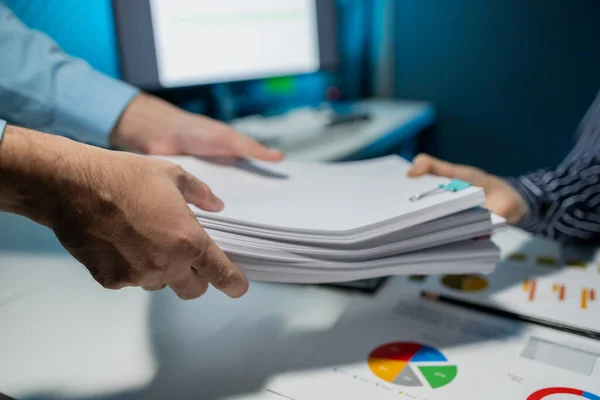 Hand a pile of important documents to a co-worker, Forward a summary of the previous month\'s meeting agenda to the department head, Big stack of documents