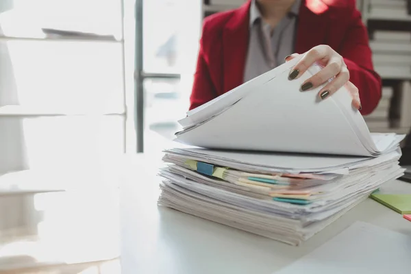 Organize large piles of documents in the office, A large number of important documents are being organized, Working alone in the office while other employees take their lunch break.