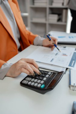 Finans veri analizinden oluşan bir ekip kağıt üzerinde iş stratejik planlama, anlayış ve gelir hesaplamak için birlikte çalışan iş adamları grubunun pazarlama göstergesi olarak çalışıyor., 