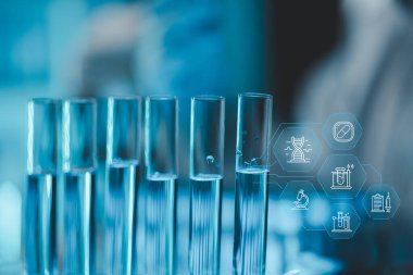 Araştırma laboratuarında teknisyen tüpü testi, kimyagerin elinde laboratuarda analiz makineleri bulunan bir raftan solüsyon örneği tüpü, pipetten tüpe sıvı damlatıyor..