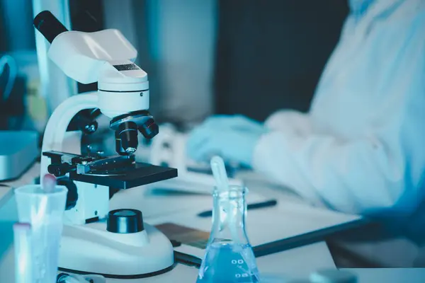 female medic in uniform working with microscope making analysis at the laboratory, Close-up shot of microscope with metal lens, A scientist is using a microscope to analyze the chemical composition,