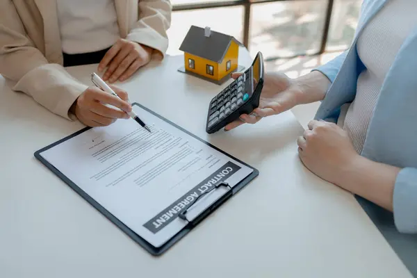 A realtor is explaining home insurance documents to a buyer in office at the company, Sign home insurance documents, make an agreement together, concerning mortgage loan offer for and house insurance