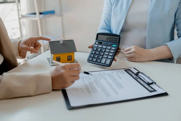 A realtor is explaining home insurance documents to a buyer in office at the company, Sign home insurance documents, make an agreement together, concerning mortgage loan offer for and house insurance