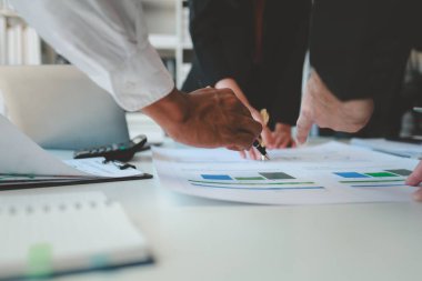 Karışık iş adamları bir masanın etrafında oturuyor ve çalışıyor iş adamları ofiste bir proje üzerinde çalışıyor ya da bir iş projesini değerlendiriyor ve tartışıyor.. 