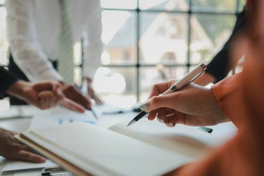 Karışık iş adamları bir masanın etrafında oturuyor ve çalışıyor iş adamları ofiste bir proje üzerinde çalışıyor ya da bir iş projesini değerlendiriyor ve tartışıyor.. 