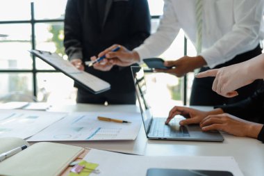 Karışık iş adamları bir masanın etrafında oturuyor ve çalışıyor iş adamları ofiste bir proje üzerinde çalışıyor ya da bir iş projesini değerlendiriyor ve tartışıyor.. 