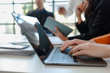 Karışık iş adamları bir masanın etrafında oturuyor ve çalışıyor iş adamları ofiste bir proje üzerinde çalışıyor ya da bir iş projesini değerlendiriyor ve tartışıyor.. 