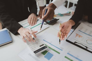 Çalışanlardan oluşan bir grup, yaklaşan bir etkinliğin detaylarını, toplantı durumunu yakından inceliyor. İş adamları ve kadınlar, şeffaf bir konferans odasında gergin bir toplantı yapıyorlar..