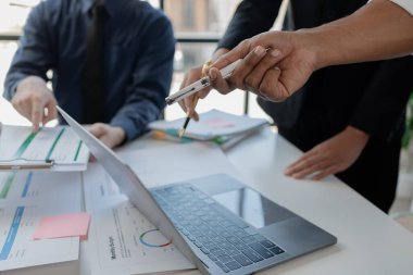 Çalışanlardan oluşan bir grup, yaklaşan bir etkinliğin detaylarını, toplantı durumunu yakından inceliyor. İş adamları ve kadınlar, şeffaf bir konferans odasında gergin bir toplantı yapıyorlar..