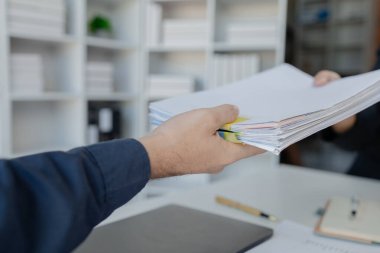 İş adamlarının elleri kağıt yığınları içinde arama için çalışır, iş adamları kağıt yığınları içinde çalışır tamamlanmamış dosyaları kontrol etmek için çalışırlar..