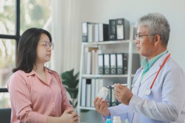 Doktor, hastanın alması gereken ilaçların detaylarını açıklarken, bir hasta ilaçların yan etkileri ile ilgili olarak doktoru görmeye gelir..