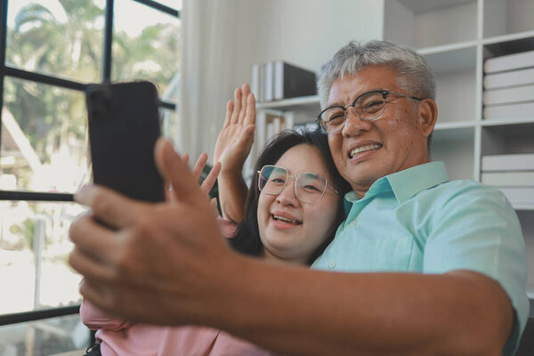 Asian father and daughter spend a happy weekend together in their home, A family of father and daughter happily do various activities together in the living room and spend quality time together.