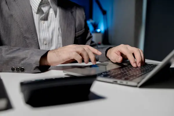 A young businessman is using a laptop to search for important information on business competitors, A laptop was used to access important documents by one employee.