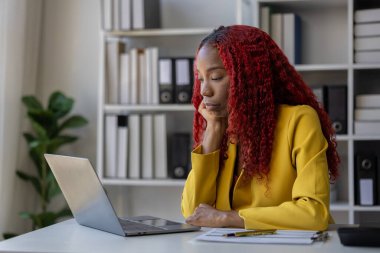 Güzel bir Afrikalı kadın çalışan işinden dolayı çok sıkılmış ve stresli, Afrikalı bir iş kadını uzun saatler çalıştığı için bitkin ve bitkin hissediyor..