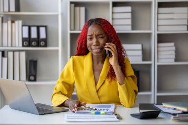 Güzel Afrikalı iş kadını iletişim kurmak ve bilgi bulmak için akıllı telefonu kullanıyor. Şu anda sorumlu olan işle ilgili olarak, bir kadın çalışan görevleri tamamlamak için bir iletişim cihazı kullanır..