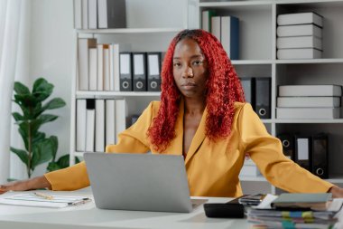 Güzel bir Afrikalı kadın çalışan işinden dolayı çok sıkılmış ve stresli, Afrikalı bir iş kadını uzun saatler çalıştığı için bitkin ve bitkin hissediyor..