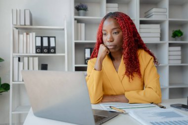 Güzel bir Afrikalı kadın çalışan işinden dolayı çok sıkılmış ve stresli, Afrikalı bir iş kadını uzun saatler çalıştığı için bitkin ve bitkin hissediyor..