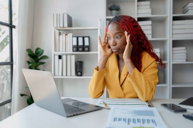 Güzel bir Afrikalı kadın çalışan işinden dolayı çok sıkılmış ve stresli, Afrikalı bir iş kadını uzun saatler çalıştığı için bitkin ve bitkin hissediyor..
