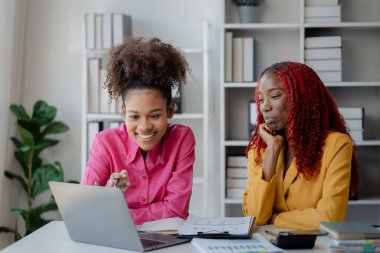 İki başarılı Afrikalı iş kadını gündüzleri şirkette birlikte iş yapma girişimlerini tartışıyorlar. Kadın Afrikalı işçiler ofiste bir proje hakkında konuşuyorlar..