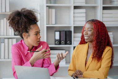 İki başarılı Afrikalı iş kadını gündüzleri şirkette birlikte iş yapma girişimlerini tartışıyorlar. Kadın Afrikalı işçiler ofiste bir proje hakkında konuşuyorlar..