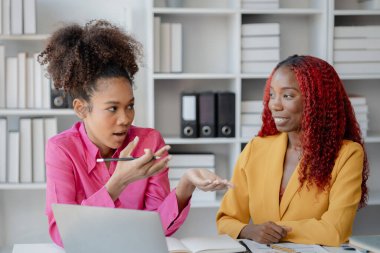 İki başarılı Afrikalı iş kadını gündüzleri şirkette birlikte iş yapma girişimlerini tartışıyorlar. Kadın Afrikalı işçiler ofiste bir proje hakkında konuşuyorlar..