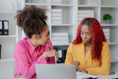İki başarılı Afrikalı iş kadını gündüzleri şirkette birlikte iş yapma girişimlerini tartışıyorlar. Kadın Afrikalı işçiler ofiste bir proje hakkında konuşuyorlar..