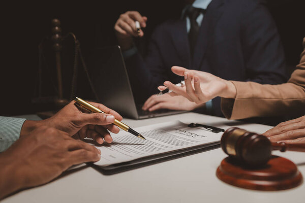 A group of lawyers is discussing contract documents that must be presented to a client, Lawyers brainstorm to revise important documents that must be submitted to the Supreme Court.