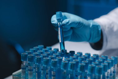 Birçok test tüpü uzmanlar tarafından incelendi, bir araştırmacı bir deney tüpünde bulunan sıvıyı dikkatle inceliyor çünkü bu önemli bir araştırma alanıdır..
