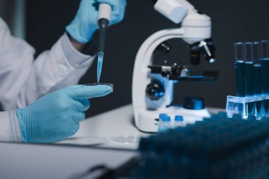 Bir araştırmacı deney tüpünde bulunan sıvıyı dikkatle inceliyor çünkü bu önemli bir araştırma alanıdır. Bir bilim adamı sıvılar üzerinde bilimsel bir deney yapmak için bir araç kullanıyor..