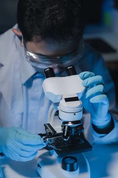 A scientist is studying samples using a microscope to study and develop the field of microbiology, Microscopes are used by researchers to study chemotherapy.