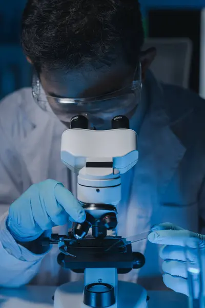 A scientist is studying samples using a microscope to study and develop the field of microbiology, Microscopes are used by researchers to study chemotherapy.