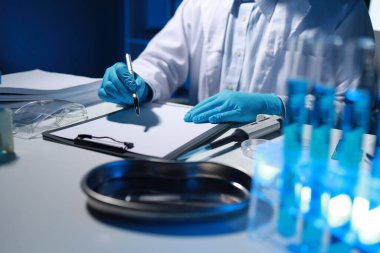 Bir araştırmacı not alıyor. Diğer araştırmacıların profili olarak laboratuvarda geliştiriliyor, bir biyolojik kimya bilimcisi bir patrona günlük çalışması hakkında bir rapor yazıyor..