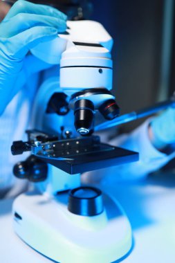 Yetenekli bir bilim adamı laboratuarında mikroskop kullanarak mikroskobik organizmaları mikroskop altında inceler. Araştırmacılar tarafından insanları tedavi etmek için yeni ilaçlar bulmak için kullanılır..