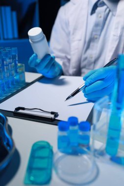 Bir araştırmacı not alıyor. Diğer araştırmacıların profili olarak laboratuvarda geliştiriliyor, bir biyolojik kimya bilimcisi bir patrona günlük çalışması hakkında bir rapor yazıyor..