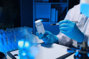 Bir araştırmacı not alıyor. Diğer araştırmacıların profili olarak laboratuvarda geliştiriliyor, bir biyolojik kimya bilimcisi bir patrona günlük çalışması hakkında bir rapor yazıyor..
