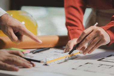 Bir mühendis ve mimar, özel bir ofiste birlikte inşa etmek üzere oldukları bina hakkında bilgi alışverişinde bulunurlar, müşteriye sunmadan önce mükemmel bir iş için birlikte tasarım yaparlar..