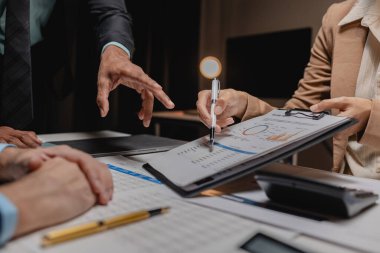 Bir grup çalışan şirketin kârını artırmak için bir strateji belirlemek üzere toplanıyor, bir grup şirket ortağı şirketin gelir verilerini değiş tokuş ediyor..