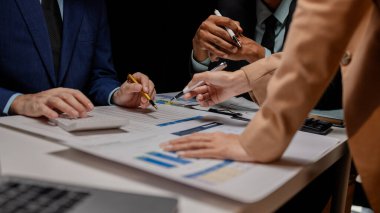 Bir grup çalışan şirketin kârını artırmak için bir strateji belirlemek üzere toplanıyor, bir grup şirket ortağı şirketin gelir verilerini değiş tokuş ediyor..