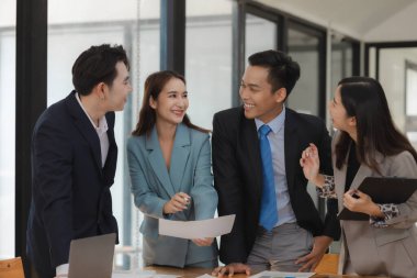 Bir grup işçi, patronlarının emrettiği gibi zamanında tamamlanan işleri tartışırken ofiste mutlu bir şekilde çalışırlar ve bir grup girişimci birlikte çalışırken eğlenirler..